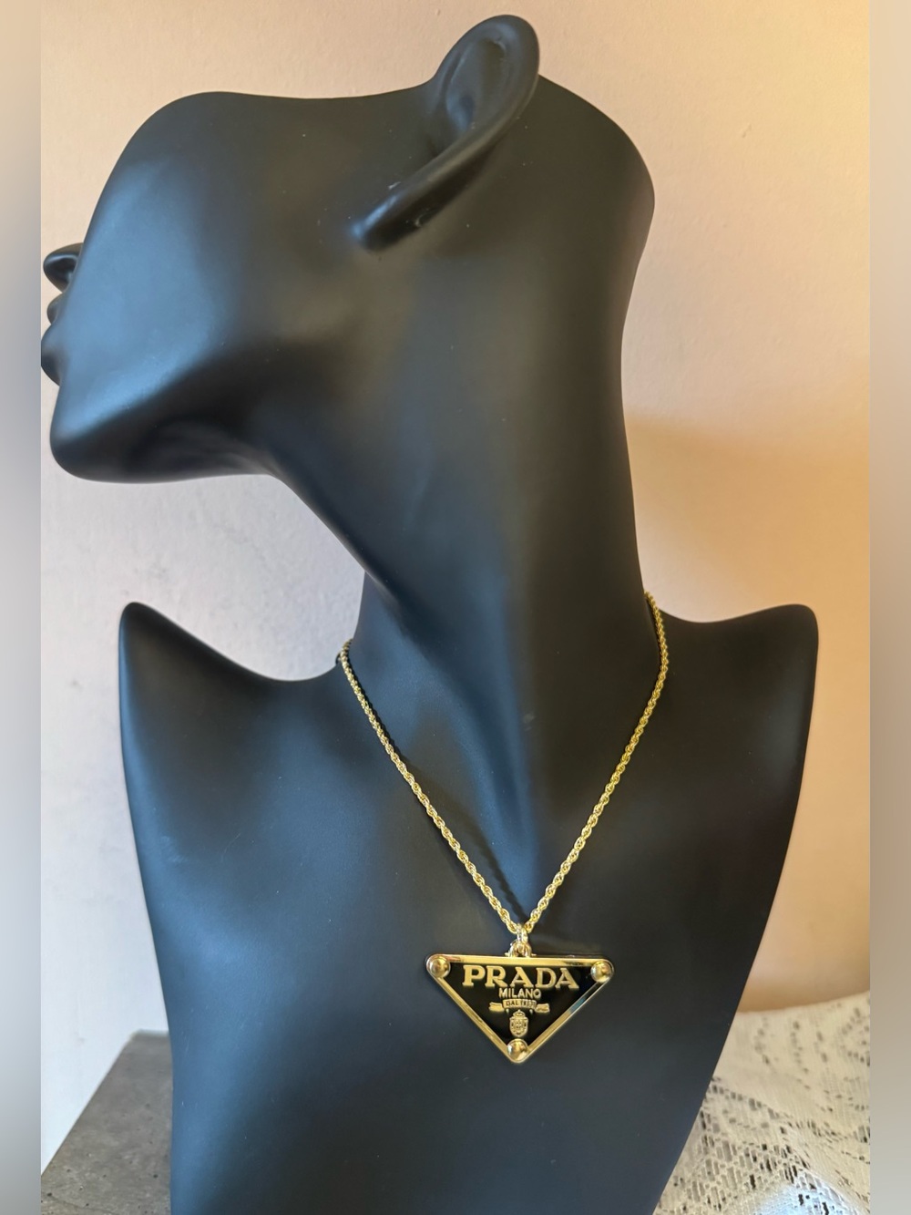 Prada Gold Triangle Logo Pendant. On a gold tone 925 16” chain.